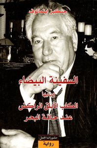 السفينة البيضاء ويليها الكلب الأبلق الراكض عند حافة البحر